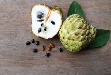 taze çiğ krema, elma şekeri, annona cherimola (annona squamosa l..) meyve, tahtadan bir masa üzerinde yalıtılmış, tropik egzotik meyve ve sağlıklı meyvelerle dilimlenmiş.