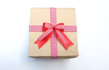   Beyaz arka planda kırmızı kurdeleli el işi kağıt hediye kutusu. Yeni yıl, Noel, Sevgililer Günü konsepti.