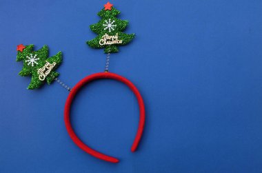 Süslü güzel saç bandı komik noel ağaçları mavi bir arka planda izole edilir. Neşeli Noel partisi konsepti, yakında yeni yıl, Noel unsurları ile şenlik sezonu dekorasyonu.