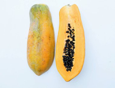 Üst ve düz, tatlı olgun papaya meyveli papaya dilimlenmiş ve yarısı beyaz arka planda yalıtılmış. Sağlıklı beslenme için sebze ve meyve.
