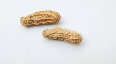 Bir yığın haşlanmış fıstık, fıstık, fındık, soyulmamış ve soyulmuş fıstık, beyaz arka planda izole edilmiş. Üst görünüm. Düz çizgi