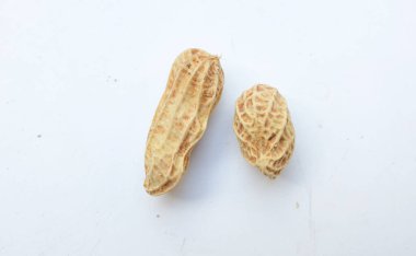 Bir yığın haşlanmış fıstık, fıstık, fındık, soyulmamış ve soyulmuş fıstık, beyaz arka planda izole edilmiş. Üst görünüm. Düz çizgi