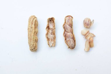 Bir yığın haşlanmış fıstık, fıstık, fındık, soyulmamış ve soyulmuş fıstık, beyaz arka planda izole edilmiş. Üst görünüm. Düz çizgi