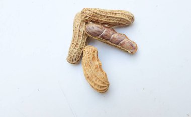 Bir yığın haşlanmış fıstık, fıstık, fındık, soyulmamış ve soyulmuş fıstık, beyaz arka planda izole edilmiş. Üst görünüm. Düz çizgi