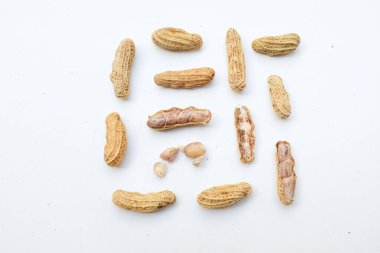Bir yığın haşlanmış fıstık, fıstık, fındık, soyulmamış ve soyulmuş fıstık, beyaz arka planda izole edilmiş. Üst görünüm. Düz çizgi
