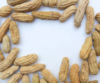 Kaynamış fıstık, fıstık, fındık, soyulmamış ve soyulmamış yer fıstığı. Beyaz arka planda izole edilmiş mesajın için boş yer var. Sağlıklı abur cubur konsepti üst görünüm.