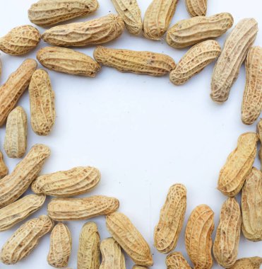 Kaynamış fıstık, fıstık, fındık, soyulmamış ve soyulmamış yer fıstığı. Beyaz arka planda izole edilmiş mesajın için boş yer var. Sağlıklı abur cubur konsepti üst görünüm.