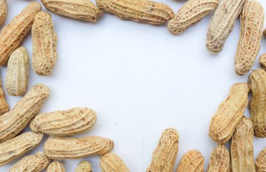 Kaynamış fıstık, fıstık, fındık, soyulmamış ve soyulmamış yer fıstığı. Beyaz arka planda izole edilmiş mesajın için boş yer var. Sağlıklı abur cubur konsepti üst görünüm.