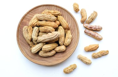 Bir yığın haşlanmış fıstık, fıstık, fındık, soyulmamış ve soyulmuş fıstık, beyaz arka planda izole edilmiş. Üst görünüm. Düz çizgi