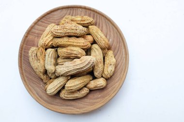 Bir yığın haşlanmış fıstık, fıstık, fındık, soyulmamış ve soyulmuş fıstık, beyaz arka planda izole edilmiş. Üst görünüm. Düz çizgi