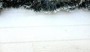 Noel ağacının süslenmiş yeşil köknar dallarından ve Noel Baba 'nın şirin çizgi filminden kalma Noel süslemeleri beyaz tahta masa arkaplanındaki dekoratif süslemeler. Boş yer özeti .  