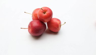 Bir grup taze organik kırmızı cüce elma, prenses elması, mini elma, küçük elma, kiraz elması, yeşil yapraklı parlak kırmızı elmalar beyaz arka planda izole edilmiş. sağlıklı meyve kavramı