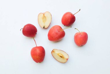 Bir grup taze organik kırmızı cüce elma, prenses elması, mini elma, küçük elma, kiraz elması, yeşil yapraklı parlak kırmızı elmalar beyaz arka planda izole edilmiş. sağlıklı meyve kavramı