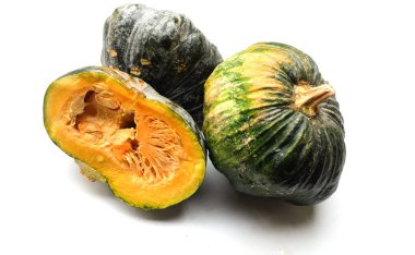 Bir yığın taze çiğ Japon balkabağı (Cucurbita moschata), Kabocha kabağı, beyaz bir arka planda izole edilmiş. Sağlıklı gıda sebze, meyve ve gıda ticareti fikri