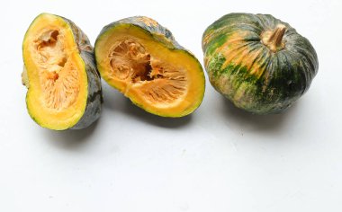 Bir yığın taze çiğ Japon balkabağı (Cucurbita moschata), Kabocha kabağı, beyaz bir arka planda izole edilmiş. Sağlıklı gıda sebze, meyve ve gıda ticareti fikri