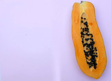 Üst ve düz bir zemin üzerinde pembe bir zemin üzerinde izole edilmiş tatlı olgun papaya meyveli papaya uzanır. Sağlıklı beslenme için sebze ve meyve.