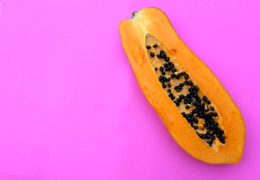 Üst ve düz bir zemin üzerinde pembe bir zemin üzerinde izole edilmiş tatlı olgun papaya meyveli papaya. Sağlıklı beslenme için sebze ve meyve.