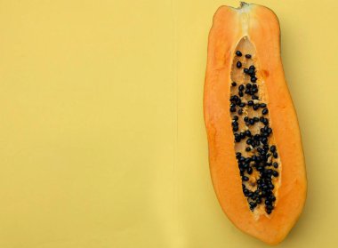 Üst ve düz bir zemin üzerinde sarı bir zemin üzerine izole edilmiş dilimlenmiş, olgun papaya meyveli papaya. Sağlıklı beslenme için sebze ve meyve.