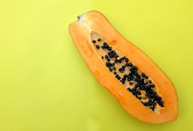Üst ve düz bir zemin üzerinde sarı bir zemin üzerine izole edilmiş dilimlenmiş, olgun papaya meyveli papaya. Sağlıklı beslenme için sebze ve meyve.
