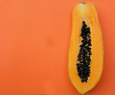 Üst ve düz bir zemin üzerinde turuncu bir zemin üzerine izole edilmiş tatlı olgun papaya meyveli papaya uzanır. Sağlıklı beslenme için sebze ve meyve.