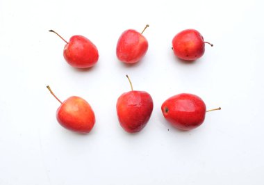 Bir grup taze organik kırmızı cüce elma, prenses elması, mini elma, küçük elma, kiraz elması, yeşil yapraklı parlak kırmızı elmalar beyaz arka planda izole edilmiş. sağlıklı meyve kavramı