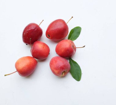 Bir grup taze organik kırmızı cüce elma, prenses elması, mini elma, küçük elma, kiraz elması, yeşil yapraklı parlak kırmızı elmalar beyaz arka planda izole edilmiş. sağlıklı meyve kavramı