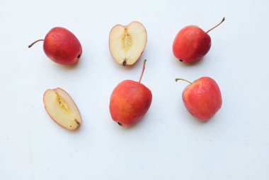Bir grup taze organik kırmızı cüce elma, prenses elması, mini elma, küçük elma, kiraz elması, yeşil yapraklı parlak kırmızı elmalar beyaz arka planda izole edilmiş. sağlıklı meyve kavramı