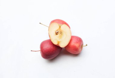 Bir grup taze organik kırmızı cüce elma, prenses elması, mini elma, küçük elma, kiraz elması, yeşil yapraklı parlak kırmızı elmalar beyaz arka planda izole edilmiş. sağlıklı meyve kavramı