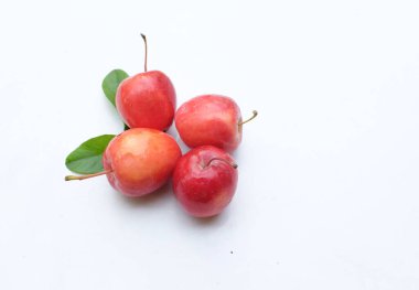 Bir grup taze organik kırmızı cüce elma, prenses elması, mini elma, küçük elma, kiraz elması, yeşil yapraklı parlak kırmızı elmalar beyaz arka planda izole edilmiş. sağlıklı meyve kavramı