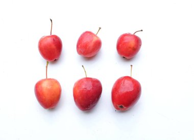 Bir grup taze organik kırmızı cüce elma, prenses elması, mini elma, küçük elma, kiraz elması, yeşil yapraklı parlak kırmızı elmalar beyaz arka planda izole edilmiş. sağlıklı meyve kavramı