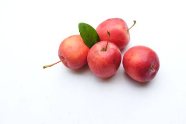 Bir grup taze organik kırmızı cüce elma, prenses elması, mini elma, küçük elma, kiraz elması, yeşil yapraklı parlak kırmızı elmalar beyaz arka planda izole edilmiş. sağlıklı meyve kavramı