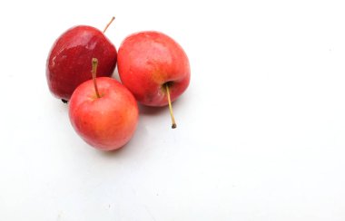 Bir grup taze organik kırmızı cüce elma, prenses elması, mini elma, küçük elma, kiraz elması, yeşil yapraklı parlak kırmızı elmalar beyaz arka planda izole edilmiş. sağlıklı meyve kavramı