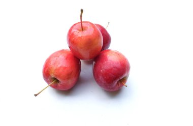 Bir grup taze organik kırmızı cüce elma, prenses elması, mini elma, küçük elma, kiraz elması, yeşil yapraklı parlak kırmızı elmalar beyaz arka planda izole edilmiş. sağlıklı meyve kavramı