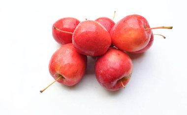 Bir grup taze organik kırmızı cüce elma, prenses elması, mini elma, küçük elma, kiraz elması, yeşil yapraklı parlak kırmızı elmalar beyaz arka planda izole edilmiş. sağlıklı meyve kavramı