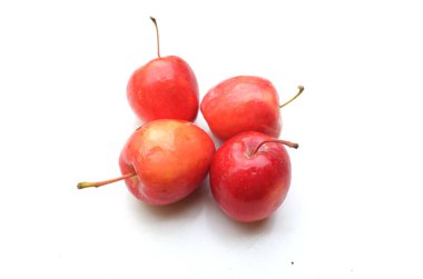 Bir grup taze organik kırmızı cüce elma, prenses elması, mini elma, küçük elma, kiraz elması, yeşil yapraklı parlak kırmızı elmalar beyaz arka planda izole edilmiş. sağlıklı meyve kavramı