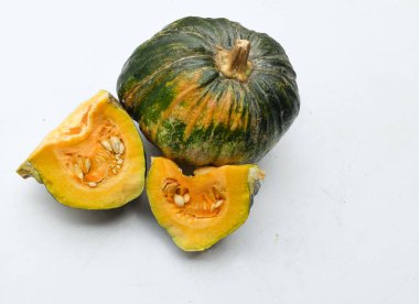 Bir yığın taze çiğ Japon balkabağı (Cucurbita moschata), Kabocha kabağı, hem top ve kesim, beyaz bir sırt üzerinde sarı et izole göstermektedir. Sağlıklı gıda sebze, meyve ve gıda işi 