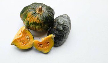 Bir yığın taze çiğ Japon balkabağı (Cucurbita moschata), Kabocha kabağı, hem top ve kesim, beyaz bir sırt üzerinde sarı et izole göstermektedir. Sağlıklı gıda sebze, meyve ve gıda işi 
