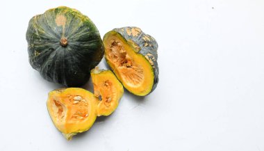 Bir yığın taze çiğ Japon balkabağı (Cucurbita moschata), Kabocha kabağı, hem top ve kesim, beyaz bir sırt üzerinde sarı et izole göstermektedir. Sağlıklı gıda sebze, meyve ve gıda işi 