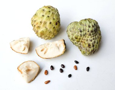 Taze yeşil kremalı elma, elma şekeri, anona cherimola (annona squamosa l.) beyaz arka planda yalıtılmış yapraklarla ikiye bölünmüş meyve. Tropikal egzotik meyve ve sağlıklı meyve