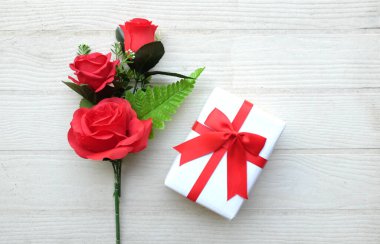 Güzel bir buket kırmızı güller ve kalpler, beyaz ahşap bir rafta el yapımı hediye kutusu metin için fotokopi alanı. Sevgililer günü konsepti. Romantik düz konum.