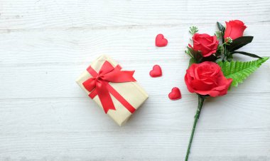 Güzel bir buket kırmızı güller ve kalpler, beyaz ahşap bir rafta el yapımı hediye kutusu metin için fotokopi alanı. Sevgililer günü konsepti. Romantik düz konum.