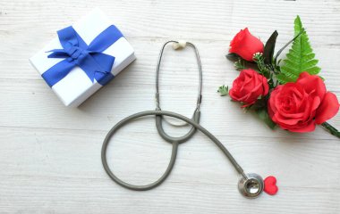 Üst manzara ve fotokopi makinesi, kırmızı güller, steteskop kırmızı kalpler, ahşap masa beyaz arka plan, Sevgililer Günü konsepti. Dünya Sağlık Günü, Doktorlar Günü, Hemşireler Günü