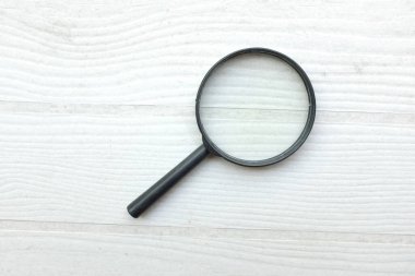 Üst görünüm ve büyüteç büyüteç loupe arama sembolü ahşap masa üzerinde izole beyaz arka fon. İnternet üzerinden bilgi aranıyor, minimal yaratıcı konsept. 