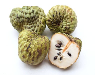 Taze yeşil kremalı elma, elma şekeri, anona cherimola (annona squamosa l.) beyaz arka planda yalıtılmış yapraklarla ikiye bölünmüş meyve. Tropikal egzotik meyve ve sağlıklı meyve