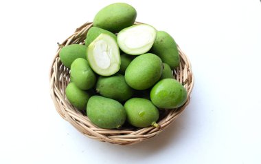 taze çiğ organik mango (Mangifera indica L. Var.) Tahta sepetlerdeki yapraklarla ikiye bölünmüş meyve, beyaz arka planda izole edilmiş. Tropikal egzotik meyve ve sağlıklı meyve