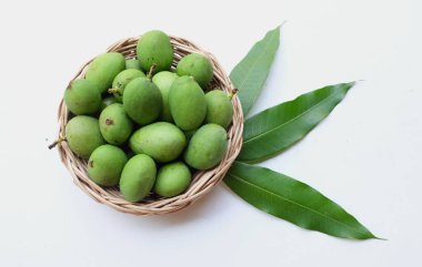 taze çiğ organik mango (Mangifera indica L. Var.) Tahta sepetlerdeki yapraklarla ikiye bölünmüş meyve, beyaz arka planda izole edilmiş. Tropikal egzotik meyve ve sağlıklı meyve