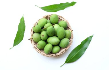 taze çiğ organik mango (Mangifera indica L. Var.) Tahta sepetlerdeki yapraklarla ikiye bölünmüş meyve, beyaz arka planda izole edilmiş. Tropikal egzotik meyve ve sağlıklı meyve