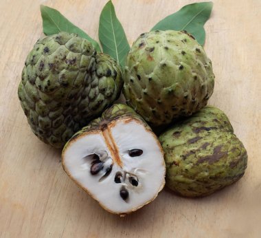 Taze yeşil kremalı elma, elma şekeri, annona cherimola (annona squamosa l.) meyve dilimlenmiş, tahta kesme tahtasının üzerinde soyutlanmış. Tropikal egzotik meyve ve sağlıklı meyve