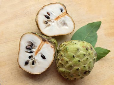 Taze yeşil kremalı elma, elma şekeri, annona cherimola (annona squamosa l.) meyve dilimlenmiş, tahta kesme tahtasının üzerinde soyutlanmış. Tropikal egzotik meyve ve sağlıklı meyve