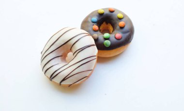 Muhtelif donutların genel manzarası. Çok renkli jöleli çikolatalı çörekler, renkli çörekler, tatlı renkli çörekler, çikolatalı vanilyalı kaplama beyaz bir fon üzerinde izole edilmiş, metin uzay görüntüsü.